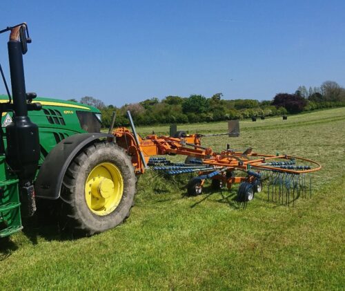 Tractor in a field with Abimac rotary rakes